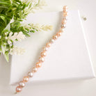 Pearl bracelet on a white box with greenery