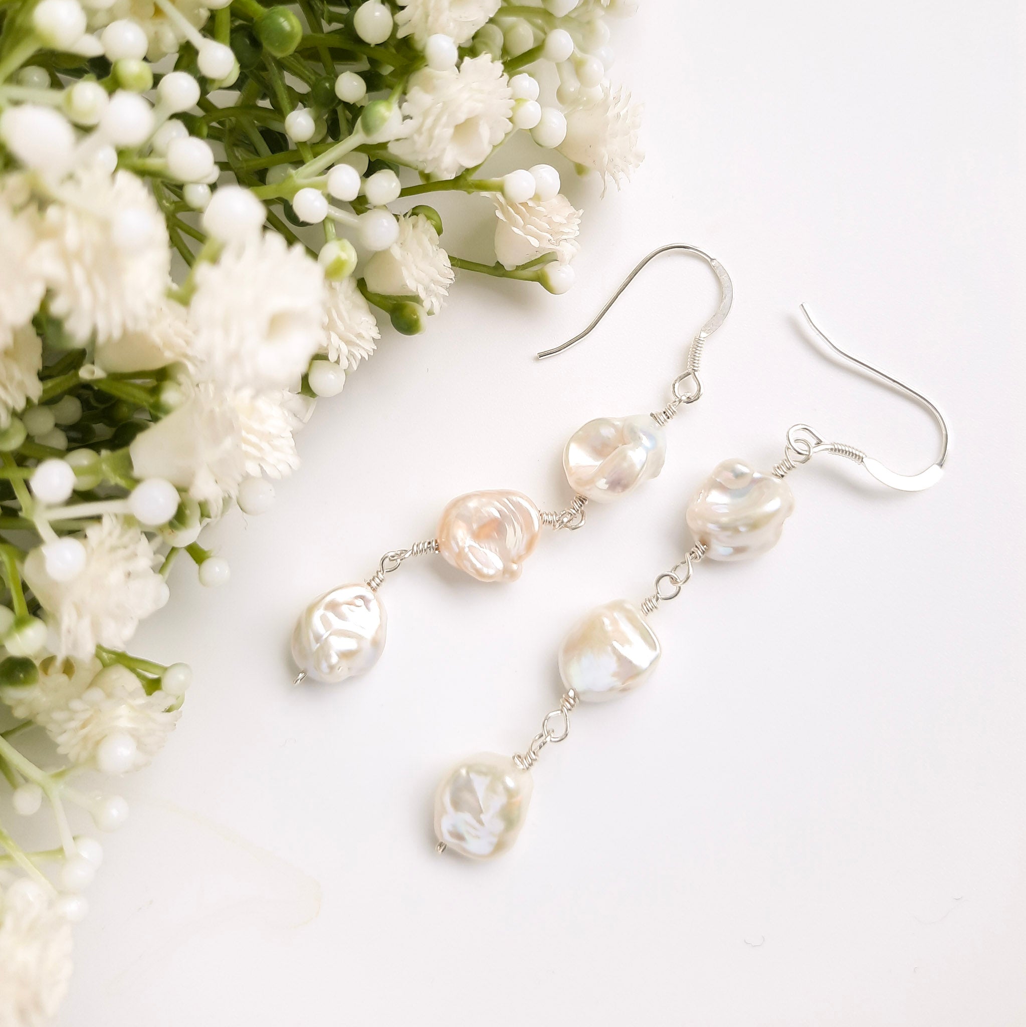 long earrings with 3 irregular shaped pearls attached with sterling silver wire and a sterling silver earring hook